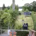 Garden with pink roses, trampoline, outdoor furniture and view of lake surrounded by trees